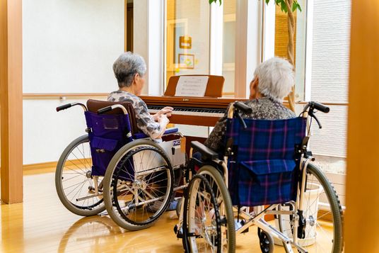 車椅子でピアノを弾く高齢者