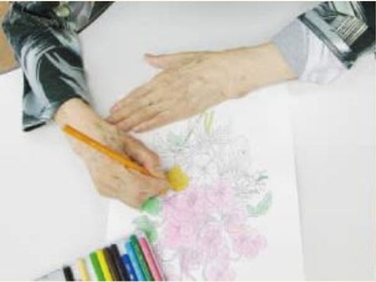 花を描く手と色鉛筆