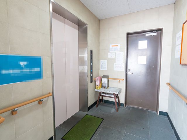 エレベーター付近の廊下 エレベーター 手すりが付いたエレベーター周辺は、安全に配慮された設計です。足元に敷かれたマットが清潔感を演出しております。