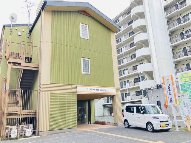 緑色の外観と駐車場 外観 清潔感のあふれる施設の正面玄関です。駐車スペースも十分にあるため、通勤にも便利です。