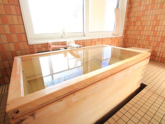 浴室に檜のバスタブが据えられている。明るい色調のバスタブには座面もついているので、ゆったりと入浴できる。