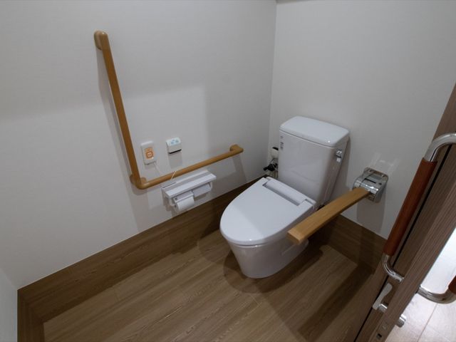 バリアフリー設計のトイレ トイレ 手すりがついた清潔なトイレです。安全と快適さを考えた設計で、多くの方にご利用いただけます。