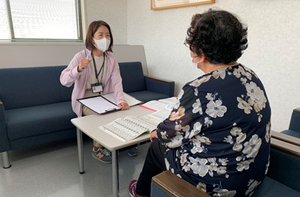相談するスタッフと入居者の室内