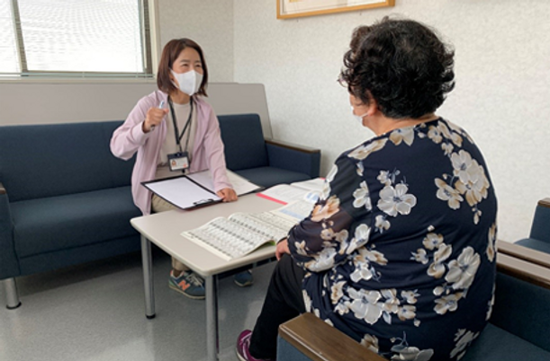 相談するスタッフと入居者の室内