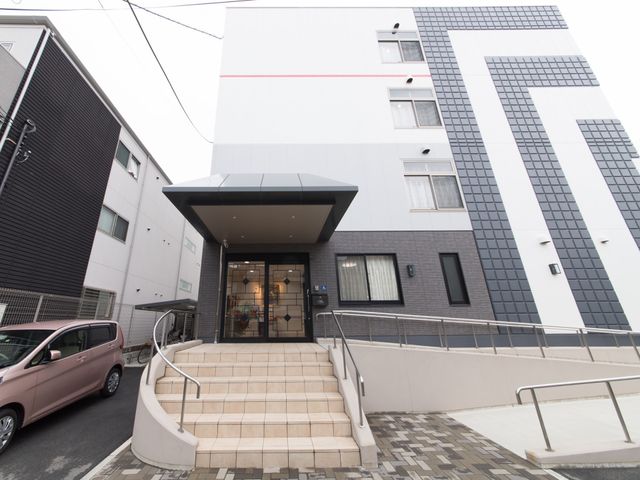 モダンな建物のエントランス 玄関 広々としたアクセスが優れたモダンなエントランスです。バリアフリー設計が求められる方に適した環境が整っています。