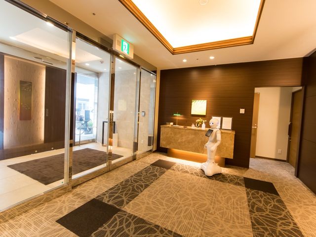 エントランスのロボットと受付 玄関ホール 広々とした清潔なエントランスです。お出迎えのロボットが訪れる方々の様子を和やかにしています。