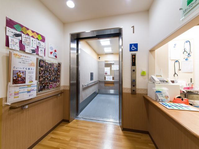 エレベーター前の廊下 エレベーター 明るい廊下が迎えてくれ、壁には掲示物が色とりどりに飾られています。