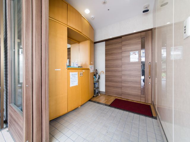 エントランスの明るい通路 入口 清潔感のあふれるエントランスには、来訪者を迎える優しい笑顔のスタッフがいます。