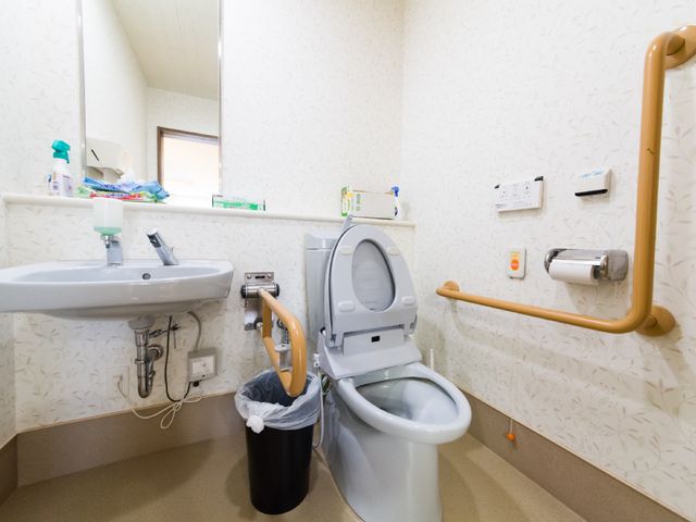 バリアフリートイレ設備 トイレ 安全な支援バー付きで清潔感のあるトイレ空間です。サポートが必要な方に配慮した設計となっています。