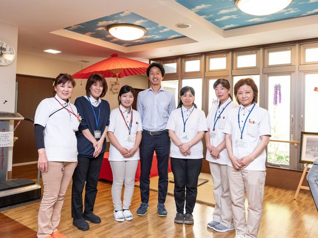 スタッフが笑顔で立つ場面