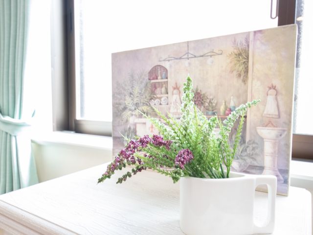 窓辺の植物と絵 飾り 窓辺に飾られた緑の植物が、居室に心温まる雰囲気をもたらしています。まるで自宅にいるような落ち着いた空間です。