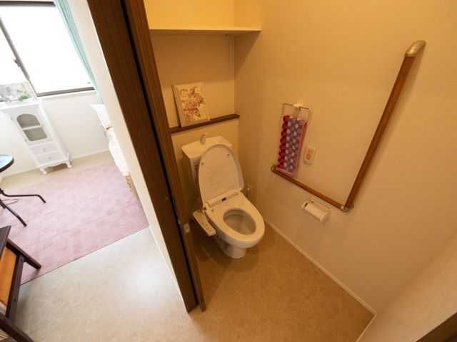 バリアフリー設計のトイレ トイレ 手すりが設置された清潔感のあるトイレ空間です。ゆったりとした動線で利用しやすくなっており、安心して働ける環境です。