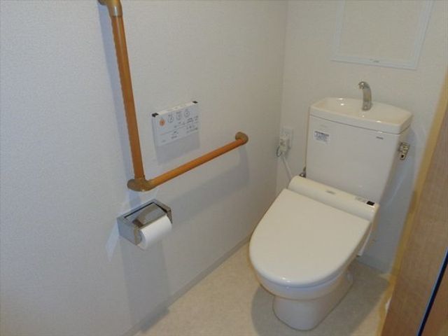 バリアフリー対応トイレ トイレ 手すりがついた安全設計のトイレです。利用者の安心と自立を支えるための配慮がされています。
