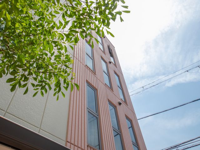 新緑が映える建物外観 外観 心地よい新緑に囲まれた施設外観です。清潔感のある建物で、働く環境の良さが感じられます。