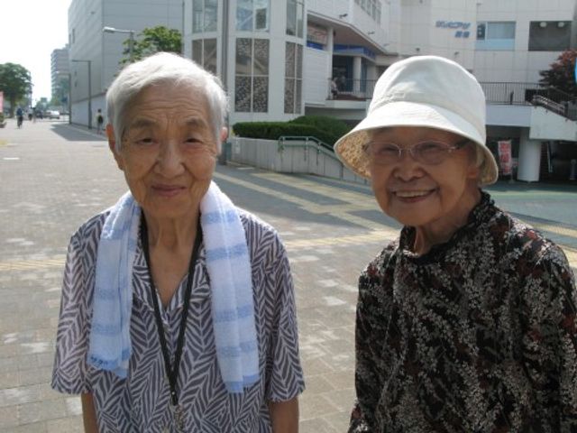 笑顔の高齢者二人外観 散策 温かい笑顔で接する利用者様同士の交流が見られ、共に支え合う環境が整っています。