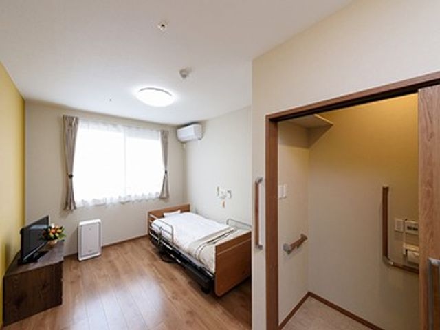 明るい居室とトイレの出入口 居室   窓から自然光が入る明るい居室です。ベッドのそばにトイレの出入口があり、移動しやすそうです。