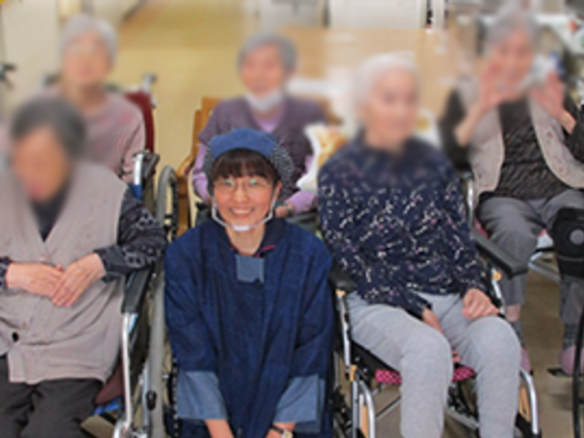 笑顔のスタッフと利用者の様子 スタッフイメージ リラックスした雰囲気の中で、利用者とスタッフが和やかに過ごしています。暖かい交流の場です。