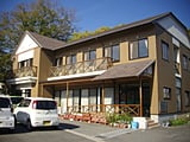 青空の下の建物外観 外観 心安らぐ環境の中に佇む建物です。広々とした敷地で、落ち着いて働くことができます。