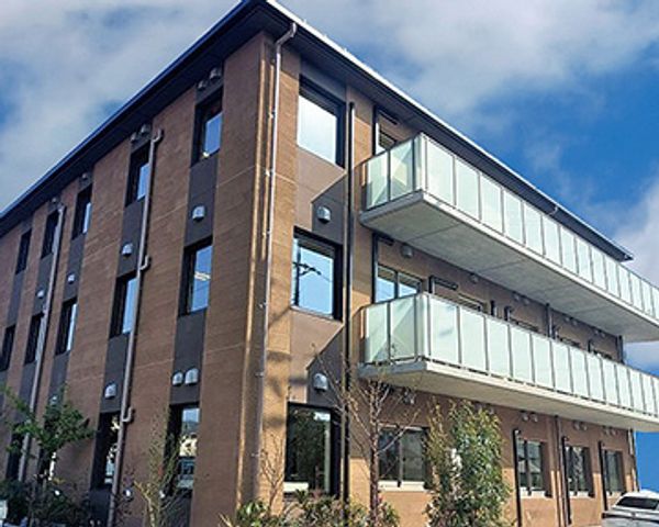 青空に映える建物の外観 外観 開放感のある三階建てで、広いバルコニーがリラックスした雰囲気を提供しています。