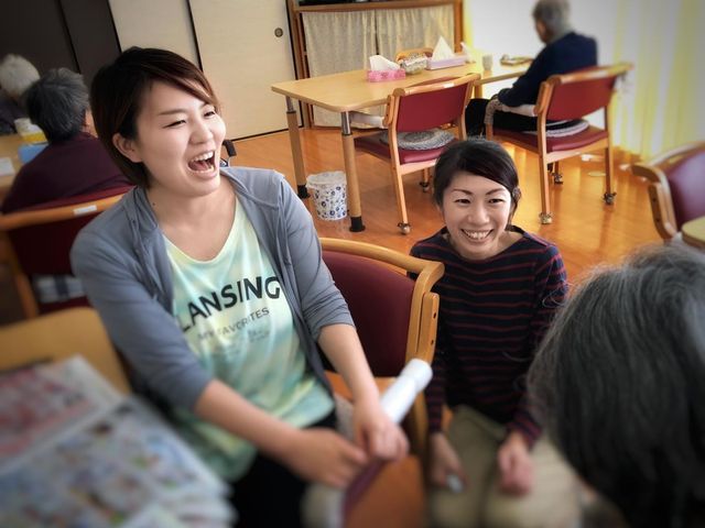 和やかな談笑が見られる居室 居室 広々とした空間で、明るい雰囲気の中、スタッフが入居者と楽しげに会話をしています。