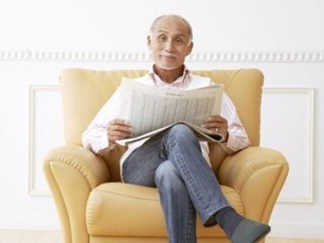 椅子に座る読書する人 ゆったりとした椅子でくつろぎながら、新聞を読む穏やかなひとときが過ごせるスペースです。安らぎを感じる勤務環境の一端をご体感いただけます。