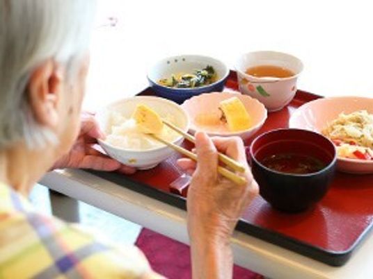 食事を取る高齢者の後姿
