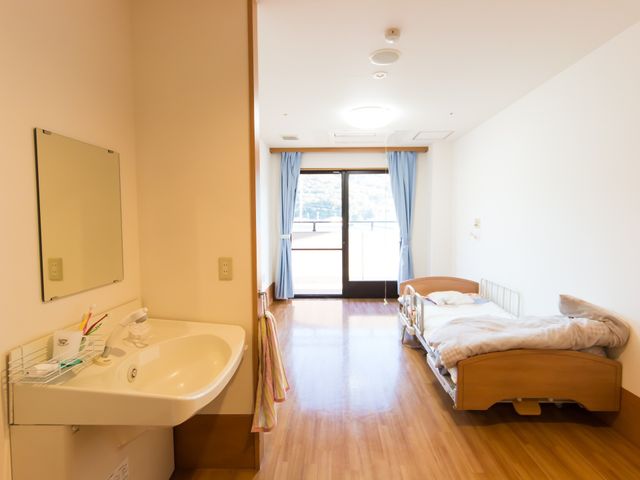 広々とした明るい居室 居室 ゆったりとしたスペースの居室です。ベッドの向かいには大きな窓があり、自然光で満たされた快適な環境が広がっています。