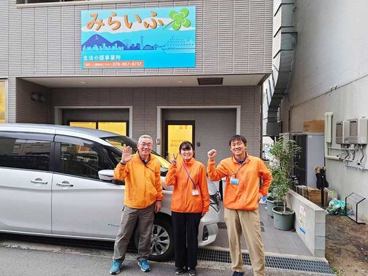 スタッフが並ぶ施設外観  