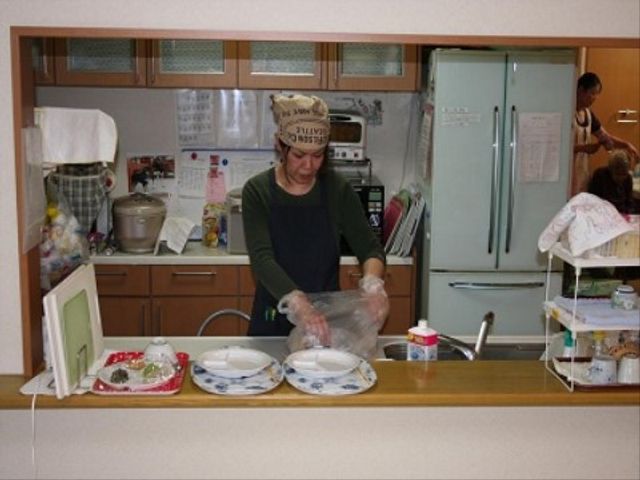 調理中のスタッフ キッチン スタッフが丁寧に食事の準備をしているキッチンです。温かみのある雰囲気が伝わる空間でご活躍いただけます。