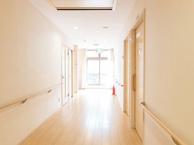 明るい廊下の様子 廊下 通路は広々としており、手すりが整備されているため、安全に歩行いただけます。窓からは自然光が差し込み、温かな雰囲気を演出しています。