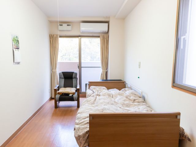 清潔感のある居室 居室 ゆったりとしたベッド、快適な椅子が備え付けられた居室です。窓からは自然光が差し込み、心地よい空間を演出しています。