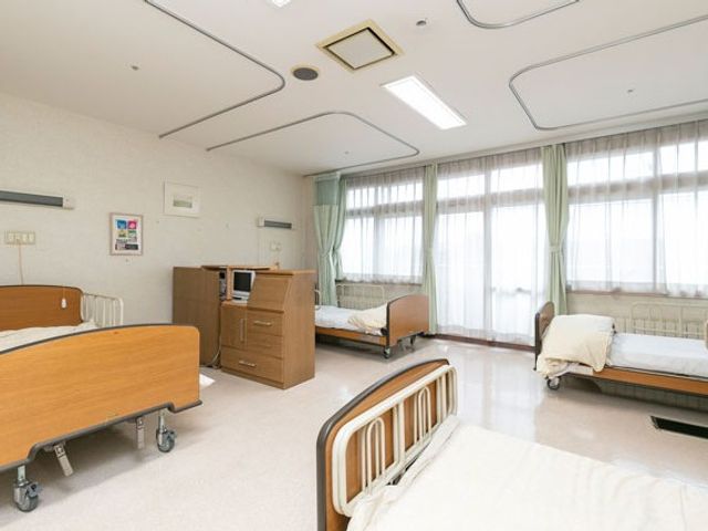 明るい居室のベッド 居室   大きな窓から光が入る、明るく清潔感のある居室です。ベッドが複数あり、ゆとりを感じるつくりです。