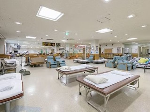 広い共有スペース リビング   天井が高く、自然光が差し込む明るい共有空間です。複数のソファやベッドがあり、ゆったり過ごしやすそうです。