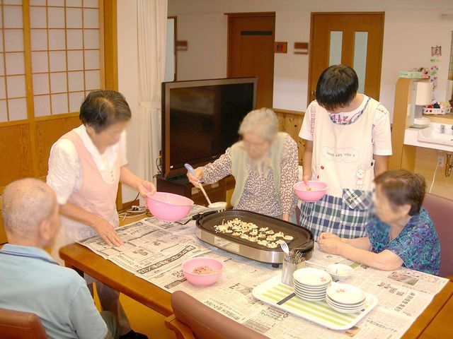 楽しむリビング リビング 自然な光が差し込む明るい空間で、入居者同士の楽しい交流が広がっています。温かい雰囲気で作業ができます。
