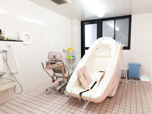 バリアフリー対応浴室 介護浴槽A 安心してご利用いただける設備が整った明るい浴室です。手すりやシャワーチェアもご用意しており、サポートが必要な方にも配慮がされています。