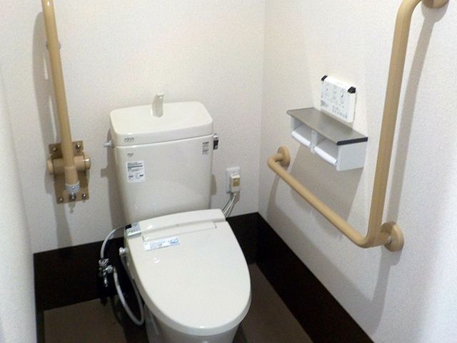 バリアフリー設計のトイレ トイレ 手すり付きの清潔感あふれるトイレ空間です。利用者の安全と利便性に配慮した設計になっております。