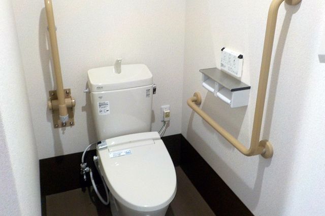 バリアフリー設計のトイレ トイレ 手すり付きの清潔感あふれるトイレ空間です。利用者の安全と利便性に配慮した設計になっております。