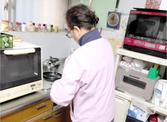 調理中の女性とキッチン