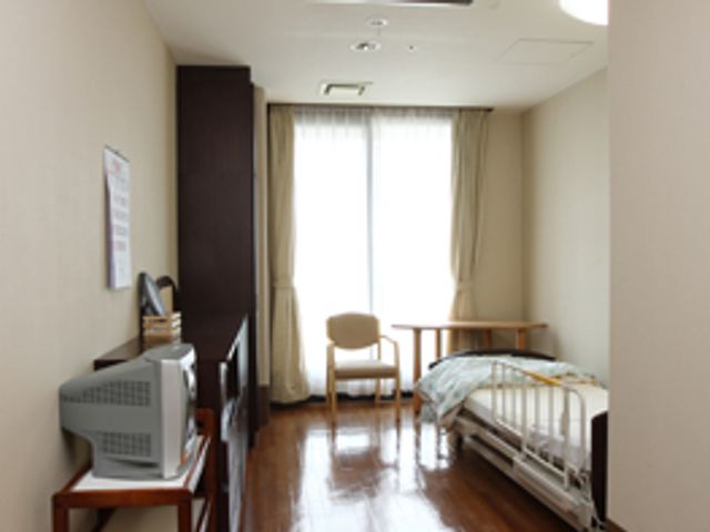 光が差し込む部屋 居室 窓から自然光が注ぐ居室です。木目調の床とシンプルな家具で落ち着いた印象を醸しています。
