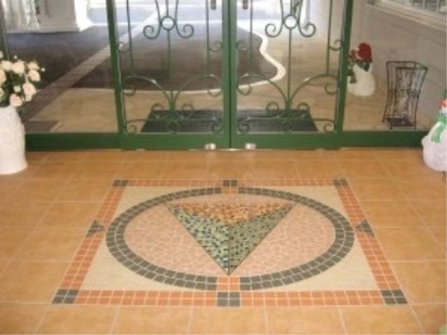 エントランスのタイルデザイン エントランス モザイクタイルが敷かれたエントランスは、訪れる人を暖かく迎えます。清潔感のある床面と明るい入り口が印象的です。