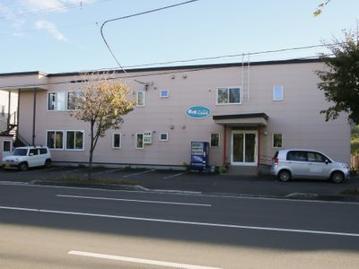 ピンクの壁の平屋建て外観