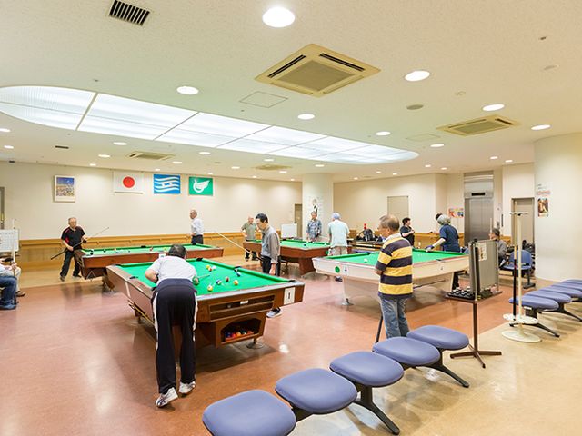 ビリヤード台がある室内 多目的室 広々とした室内にはビリヤード台が複数設置され、皆さんが楽しんでいる様子が見られます。自然光が差し込む明るい空間でリラックスできます。