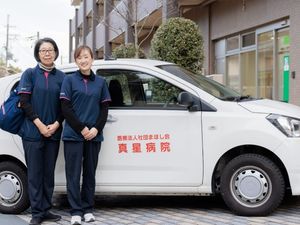 送迎車前のスタッフ  