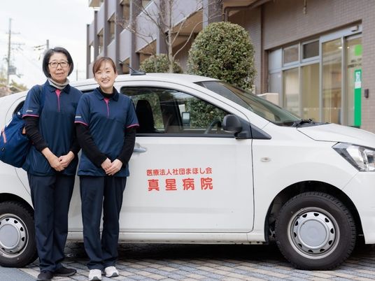 送迎車前のスタッフ  