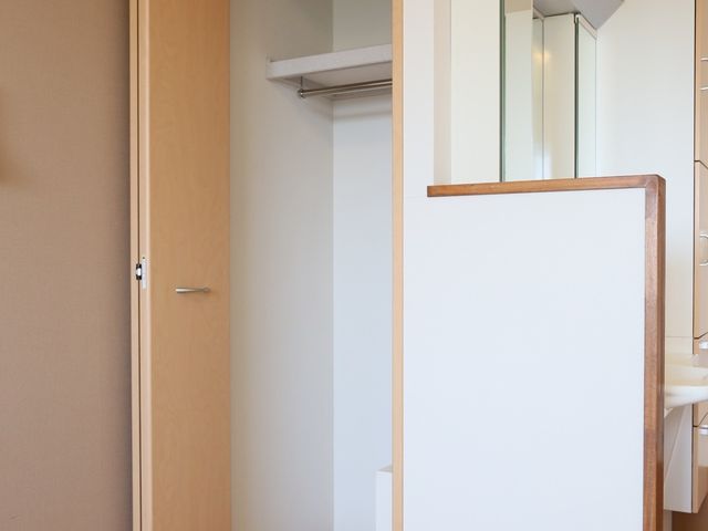 木製の洗面台と扉 収納 洗練されたデザインの洗面スペースです。日々の身支度に便利な収納が備わっており、快適な環境が提供されています。
