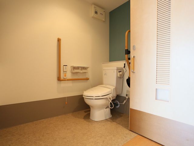 手すり付き清潔なトイレ トイレ 手すりと広々とした空間を備えた安心のトイレです。利用者の自立を支援する工夫が行き届いています。
