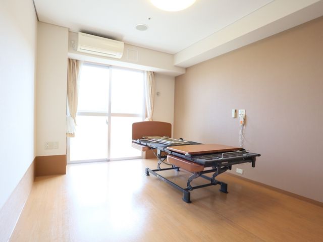 明るい居室の一角 居室 日差しが心地よい居室には、使い勝手の良いベッドが配置されており、快適な個人空間を提供しています。窓からの景色もお楽しみいただけるでしょう。
