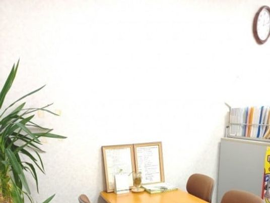 机と掲示物のある一角の居室  