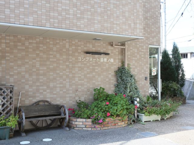 コンクリート介護施設外観 外観 花々が彩る心和む施設のエントランスは、訪れる方々に穏やかな印象を与えます。落ち着いた色合いの建物が、快適な勤務環境を予感させます。