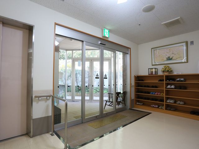 エントランスの落ち着いた雰囲気 玄関 ゆったりとしたエントランスは明るく、訪れる方々を温かく迎え入れています。靴を整然と収納できる棚が設けられ、清潔感があります。